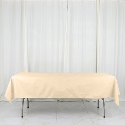 Beige tablecloth draped over a folding table in a studio setting.