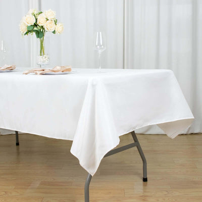 White tablecloth draped elegantly over a folding table with floral centerpiece.