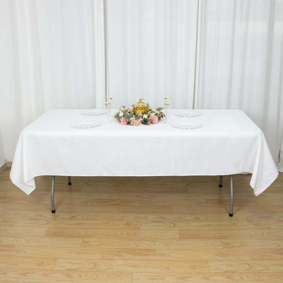 White table set with floral centerpiece and plates for dining.