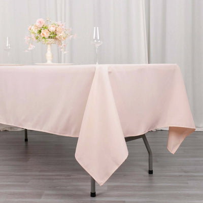 Pink tablecloth draped elegantly on a table with floral centerpiece and glassware.