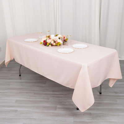 Elegant pink tablecloth draped over a table with floral centerpiece and plates.