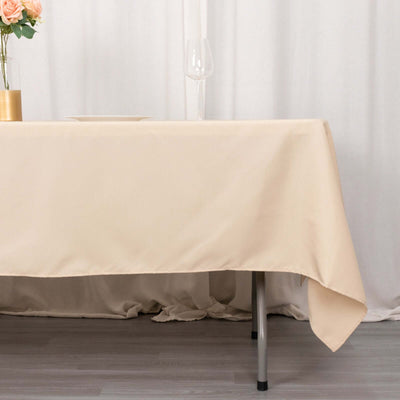 Beige tablecloth draped over a table in a styled setting.