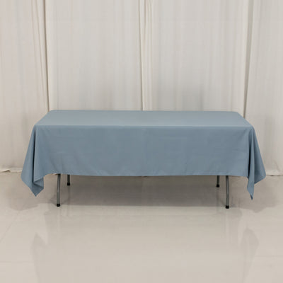 Blue tablecloth draped over a rectangular table on a plain backdrop.