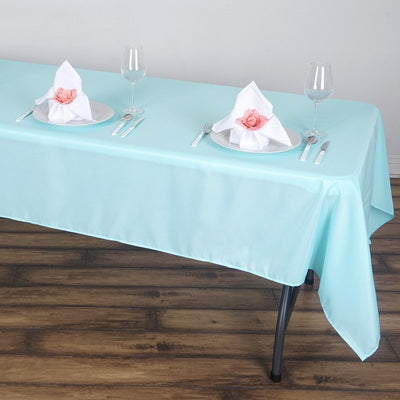 Table set with mint tablecloth, elegant place settings, and floral napkin accents.