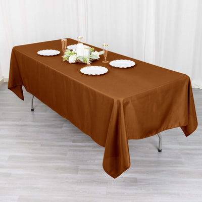 Brown tablecloth draped over a table set for dining.