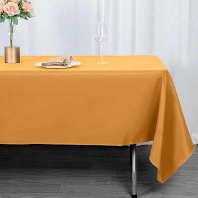 Orange tablecloth draped over a table with elegant dining setup.