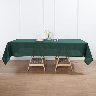 Green tablecloth draped over a wooden table with decorative items.