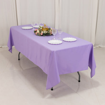 Purple tablecloth draped over a folding table with decorative plates and glasses.