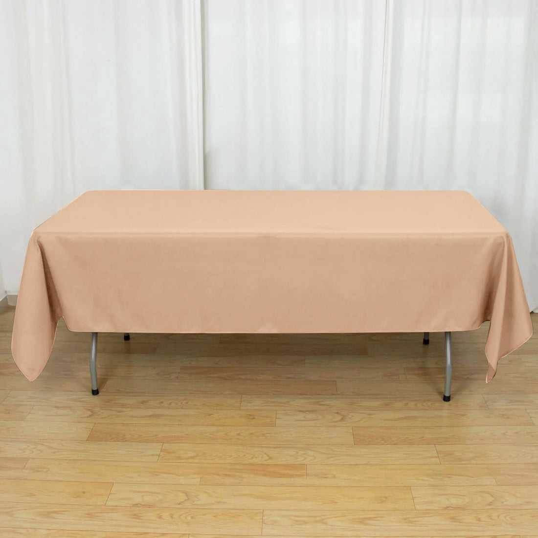Peach tablecloth draped over a folding table in a bright setting.