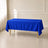 60"x102" royal blue rectangular tablecloth draped over a table with gold legs, set in a bright room with cream walls, white curtains, and tiled floors.