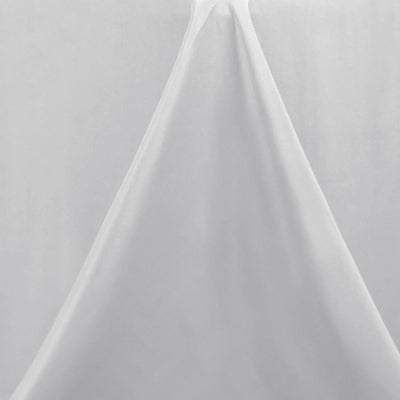 White fabric draped elegantly on a plain backdrop.