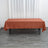 Brown tablecloth draped over a folding table in a minimalist setting.