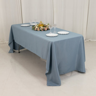 Blue tablecloth draped over a table set with plates and glasses.