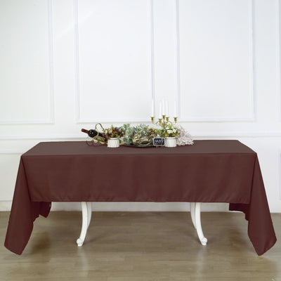 Brown tablecloth draped over a table with decorative items and candles.