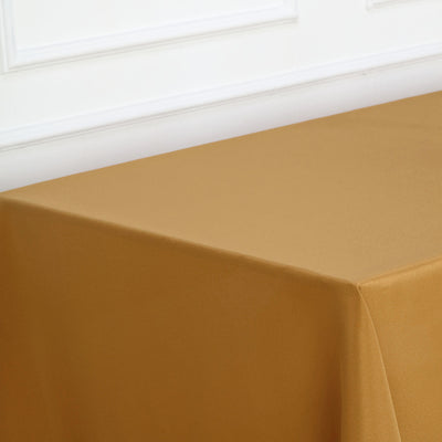 Golden tablecloth draped over a table against a white backdrop.