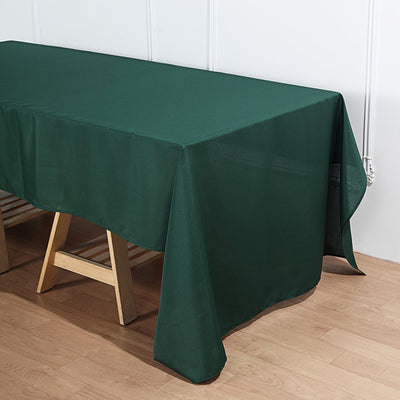 Green tablecloth draped over a wooden table.