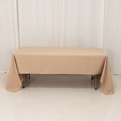 Beige tablecloth draped over a rectangular table in a studio setting.