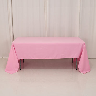 Pink tablecloth draped over a rectangular table in a studio setting.