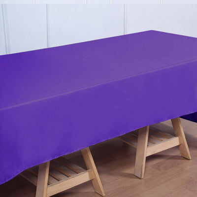 Purple tablecloth on a wooden table with a plain background.