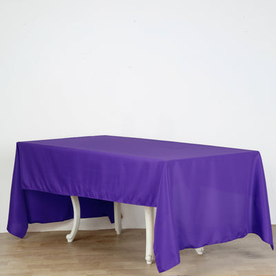 Purple tablecloth draped over a white table in a clean setting.