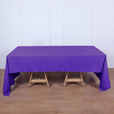 Purple tablecloth draped over a wooden table in a staged setting.