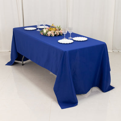 Blue tablecloth on a table set with glassware and floral centerpiece.