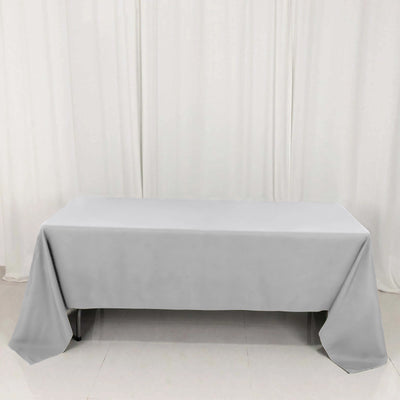 Gray tablecloth draped over a table against a plain backdrop.