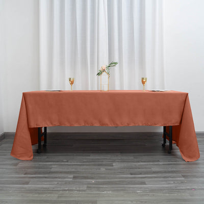 Rust-orange tablecloth draped over a table with decorative elements