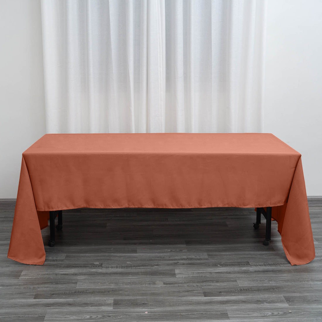 Rust-colored tablecloth draped over a table in a minimalist setting.