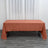 Rust-colored tablecloth draped over a table in a minimalist setting.