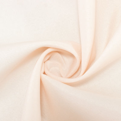 Soft peach fabric with a smooth texture in a spiral arrangement. #whtbkgd