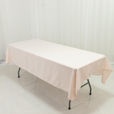 Beige tablecloth draped over a folding table in a studio setting.