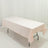 Rectangular table with a soft pink tablecloth on a plain backdrop
