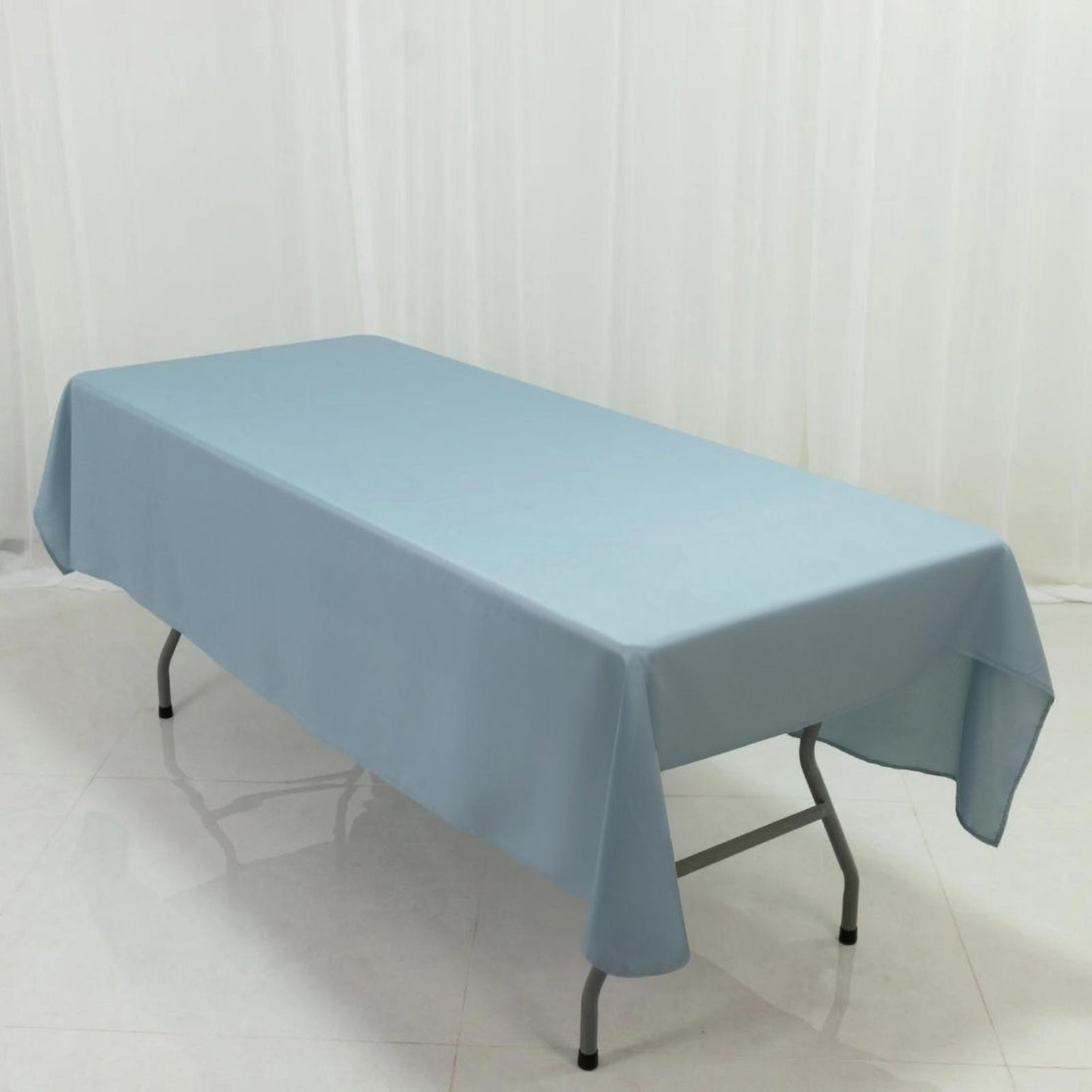 Blue tablecloth draped over a folding table in a studio setting.
