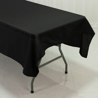 Black tablecloth draping over a folding table in a studio setting.