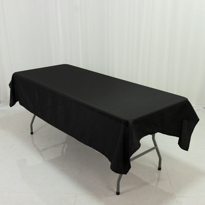 Black tablecloth draped over a folding table in a studio setting.