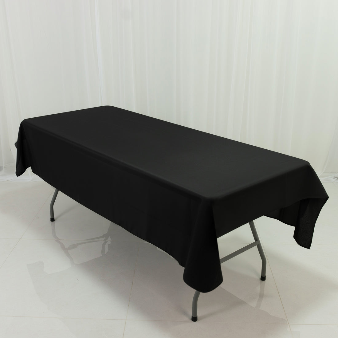 Black tablecloth draped over a folding table in a studio setting.