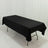 Black tablecloth draped over a folding table in a studio setting.