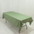 Green tablecloth draped over a folding table on a plain backdrop.