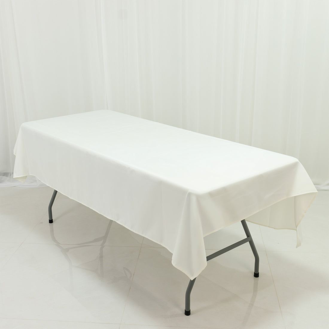White tablecloth draped over a folding table on a plain background