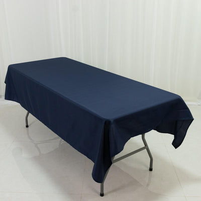 Navy tablecloth draped over a folding table on a plain backdrop.