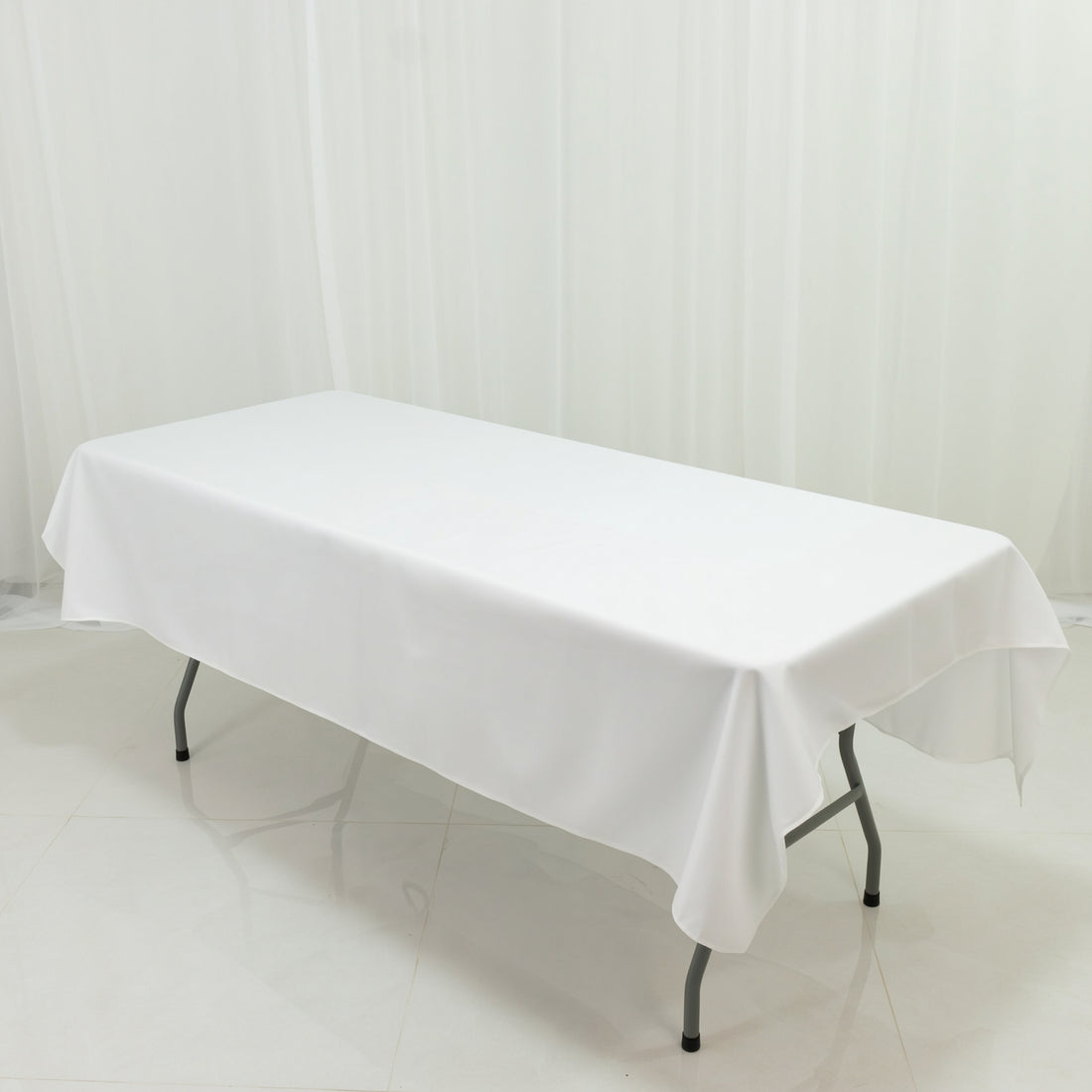 White table covered with a tablecloth in a bright, clean setting.