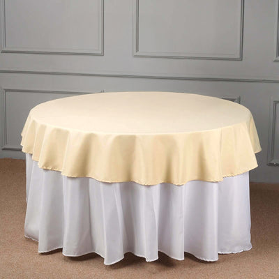 Round table with a yellow and white tablecloth.