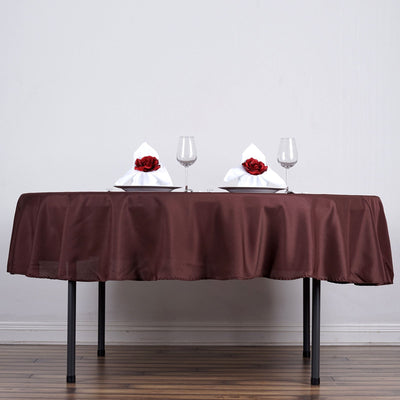 Elegant dining table set with rose-adorned napkins and glasses.