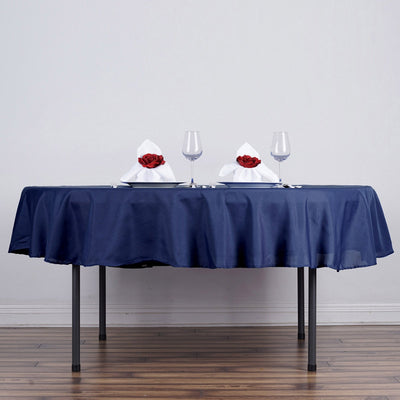 Elegant navy tablecloth with rose-adorned napkins and glassware set for dining.