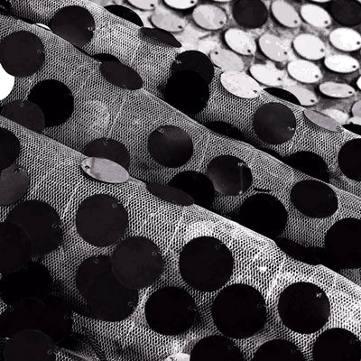Black sequin fabric texture with circular sequins shimmering in light. #whtbkgd