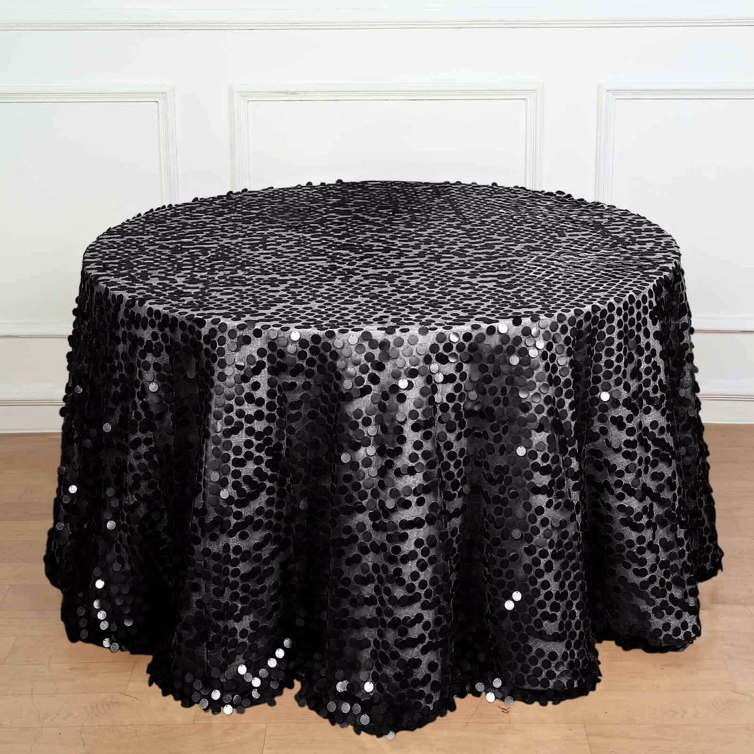 Black sequin tablecloth on a round table, elegant for events and parties.