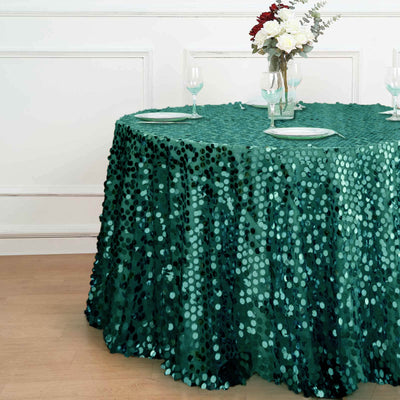 Green sequin tablecloth draped on a round table with floral centerpiece.