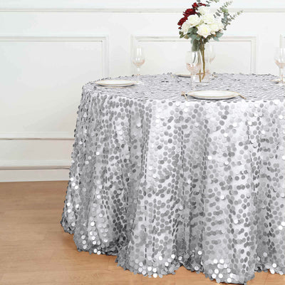 Silver sequin tablecloth draped on a round table with floral centerpiece.