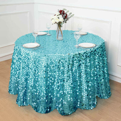 Round table with turquoise sequin tablecloth and elegant dining setup.